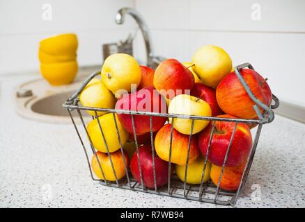 Des pommes dans un panier sur la table de cuisine Banque D'Images