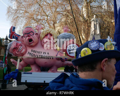 Londres, Royaume-Uni. 11 décembre 2018. Un manifestant « stop Brexit » portant des badges sur son chapeau se tient devant le modèle de monstrosité du Brexit directement à l'extérieur des Houses of Parliament. La remorque, sur laquelle est inscrit « Brexit est une monstrosité », caricature Theresa May, Boris Johnson, Michael Gove et David Davis. Les manifestations ont eu lieu un jour après que la Première ministre Theresa May ait reporté le vote des Communes sur son accord de retrait du Brexit ; elle a passé la journée à faire le tour des capitales européennes pour obtenir des assurances, et un vote de défiance contre sa direction a été déclenché le jour suivant. Credit: Ben Slater/Alamy Live News Banque D'Images