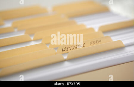 Dossiers jaune avec des étiquettes et du papier dans une rangée Banque D'Images