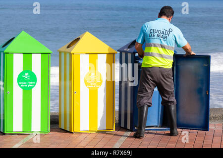 Travailleur du Conseil de vider les poubelles de couleur pour le recyclage plastique, papier, produits bio...sur la plage en Espagne Banque D'Images