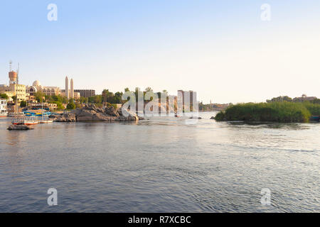 Vue sur rivière du Nil à Assouan avec la cathédrale copte orthodoxe de l'Archange Michel au coucher du soleil Banque D'Images