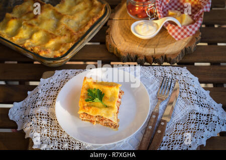 Classic hommade Lasagnes à la sauce bolognaise sur table en bois avec nappe en dentelle Banque D'Images