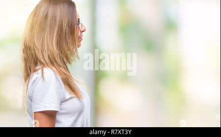 L'âge moyen hispanic woman wearing fashion sunglasses sur fond isolé à côté de beauté, posent avec profil visage naturel avec confiance smi Banque D'Images