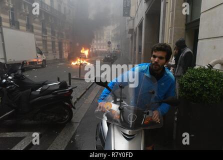 Décembre 01, 2018 - Paris, France : Jimmy Crombez, 32 ans, propriétaire d'une start-up, essaie de lui enlever son scooter loin de la rue où il vit, où plusieurs véhicules ont été mis en feu. Un habitant recupere son scooter pour l'eloigner tandis que des gilets jaunes et des les casseurs mettent le tau un des véhicules dans sa rue en marge d e l'acte 3 des gilets jaunes a Paris. Cette manifestation a rapidement degenere en affrontement avec les CRS filtrant l'entrée de l'avenue des Champs-Elysées. *** FRANCE / PAS DE VENTES DE MÉDIAS FRANÇAIS *** Banque D'Images