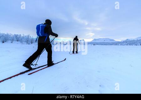 La Suède, la Laponie, région classée au Patrimoine Mondial de l'UNESCO, comté de Norrbotten, skieurs nordiques en Abisko National Park avec Laporten en arrière-plan3 Banque D'Images