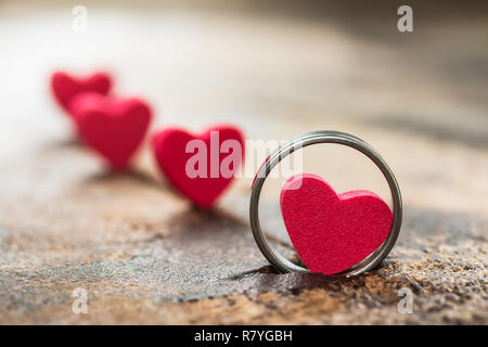 Une photo de petit coeur dans l'anneau sur le vieux bois. table valentine concept. Soft focus et sélective. Banque D'Images