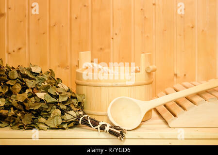 Un seau en bois, un balai de bouleau et d'autres accessoires dans un sauna finlandais ou le bain russe classique. Espace libre sur un fond de bois Banque D'Images