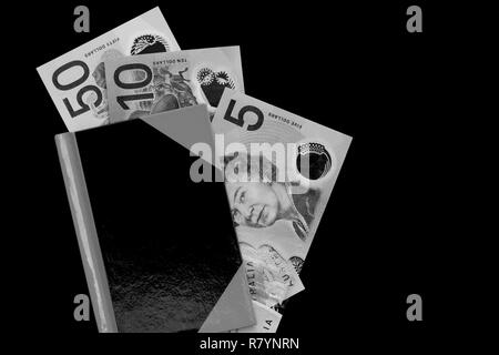 Australian dollar notes dans un ordinateur portable en noir et blanc. Banque D'Images