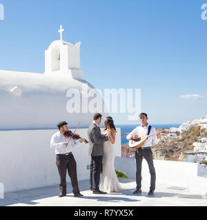 Bride and Groom dansing lors de la cérémonie du mariage sur l'île de Santorin, Grèce. Banque D'Images