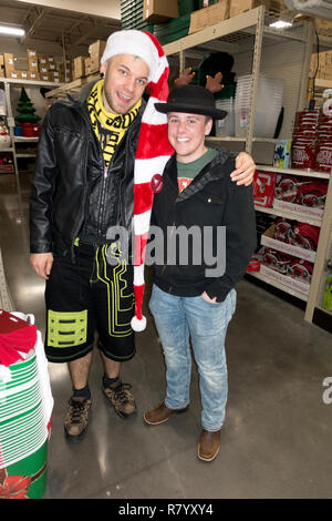 Deux acheteurs de Noël jolly porter du rouge et blanc chapeau bas dépouillé et un chapeau d'affaires à Menards. St Paul Minnesota MN USA Banque D'Images