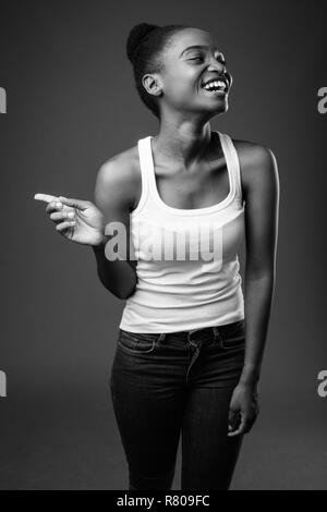 Belle jeune femme zoulou africain rire et doigt en noir et blanc Banque D'Images