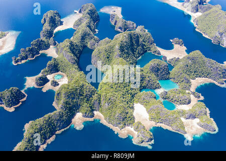 Les récifs coralliens peu profonds à distance surround îles calcaires à Raja Ampat, en Indonésie. Cette région riche en biodiversité, est connu comme le "cœur du Triangle de Corail.' Banque D'Images