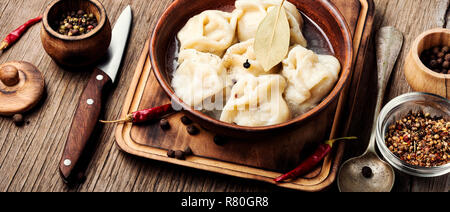 Un plat traditionnel russe.pelmeni sur beignets de viande fond rustique en bois Banque D'Images