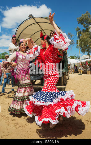 Au cours de l'assemblée la Pentecôte pèlerinage de El Rocio les femmes portent des robes colorées et joliment gypsy dance facilement la sevillana. La province de Huelva, Andalousie, espagne. Banque D'Images