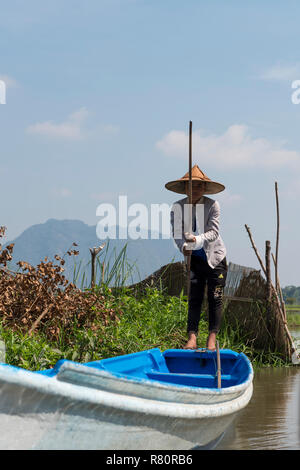 HPA-AN, LE MYANMAR - 19 novembre, 2018 : Vertical photo de jeune femme birmane s'habiller vêtements traditionnels et un chapeau, voile bateau dans la rivière à proximité Banque D'Images