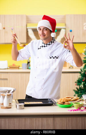 Jeune chef mari travaillant en cuisine à la veille de Noël Banque D'Images