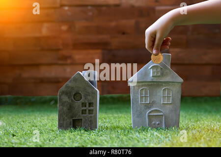 Mettre la main en forme de pièce de maison tirelire pour économiser de l'argent pour l'achat d'une maison Banque D'Images