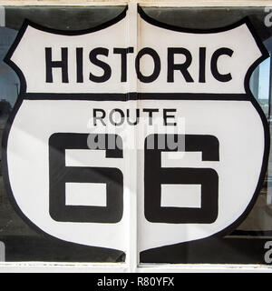 Tucumcari NM / United States - Juillet 18, 2016 : l'Autoroute Route 66 géant peint symbole signe sur une ancienne station d'essence abandonnés et vitrine Banque D'Images