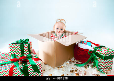 Mignon bébé fille 1 ans assis dans la case sur fond de Noël. Maison de vacances, célébration, kid concept Banque D'Images