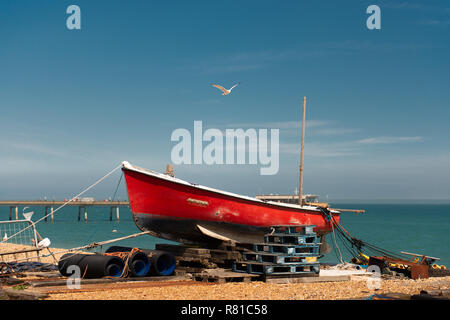 Mouette voler au-dessus de la voile rouge sur la plage avec l'homologue dans l'arrière-plan. Prises dans le Kent, UK. Banque D'Images