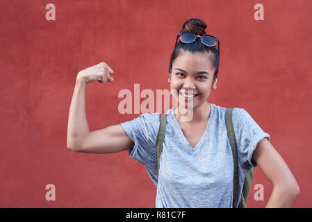 Young Asian Woman Woman flexing biceps avec humour son extérieur Banque D'Images