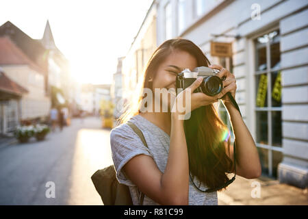 Smiling Young Asian woman taking photos dans la ville Banque D'Images