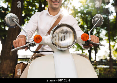 Portrait d'un jeune homme assis sur une moto à l'extérieur Banque D'Images
