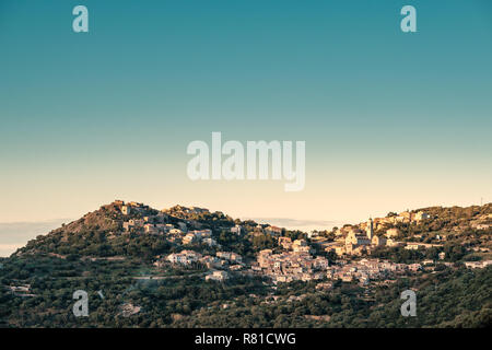 L'ancien village de montagne de Corbara éclairées par le soleil de l'après-midi et entouré d'arbres dans la région de Balagne Corse avec le Mediterran Banque D'Images