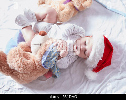 Happy Baby in Santa's hat avec des jouets mous Banque D'Images