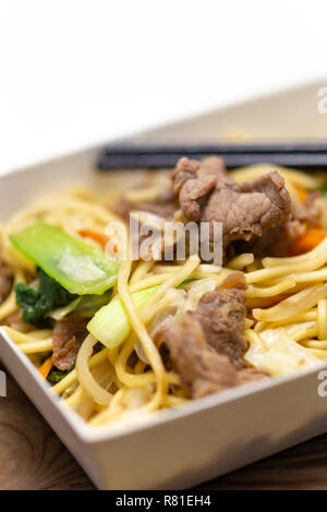 Riz frit au porc chinois dans la boîte à lunch avec des baguettes Banque D'Images