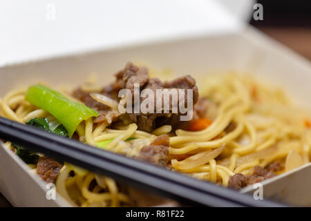 Riz frit au porc chinois dans la boîte à lunch avec des baguettes Banque D'Images