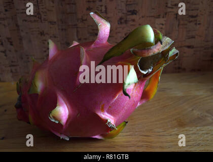 Résumé formé sweet dragon fruit à peau rose, ripe fruit également appelé pitaya Hylocereus undatus sur table en bois Banque D'Images