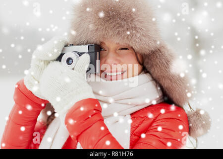 Femme heureuse avec film appareil photo à l'extérieur en hiver Banque D'Images