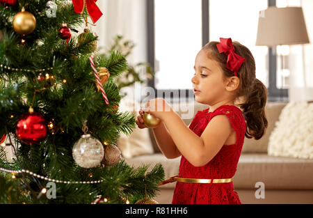 Little girl decorating Christmas Tree at home Banque D'Images