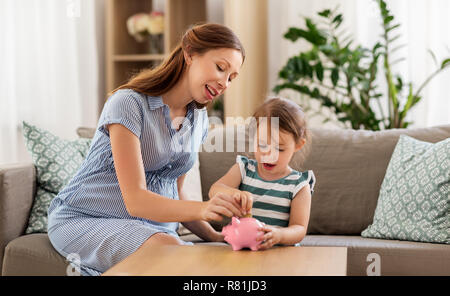 Mère et fille enceinte avec piggy bank Banque D'Images