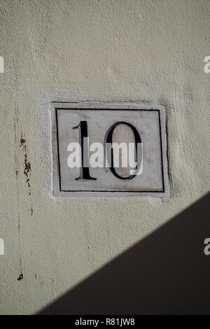 Numéro dix sur une plaque de marbre sur un mur de plâtre Banque D'Images