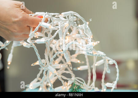 Jeune femme tenant les lumières de Noël Banque D'Images