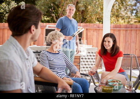 Couple de personnes adultes, enfants d'un barbecue à l'extérieur chambre Banque D'Images