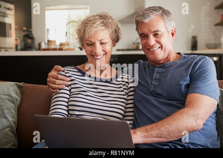 Couple sur le canapé à la maison à l'aide d'ordinateur portable, Close up Banque D'Images