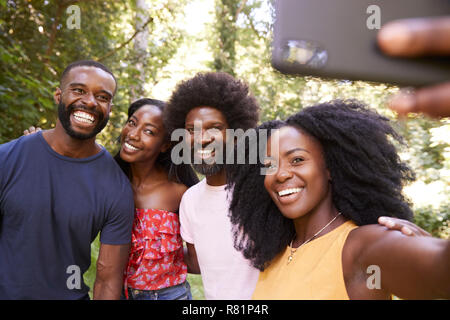 Quatre amis adultes prendre un au cours d'une randonnée forêt selfies Banque D'Images