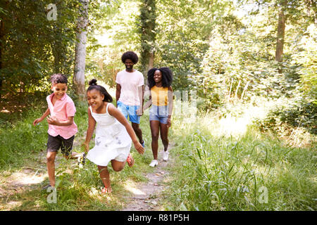 Noir un couple et leurs deux enfants marcher dans une forêt Banque D'Images