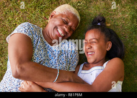 Black girl et grand-mère couchée sur l'herbe, les frais généraux close up Banque D'Images