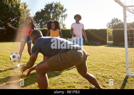 Quatre amis adultes ayant un amusant jeu de football Banque D'Images