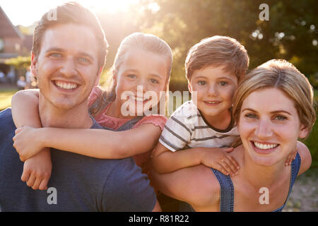 Portrait Of Smiling Family l'extérieur en été Park contre Sun Torchage Banque D'Images