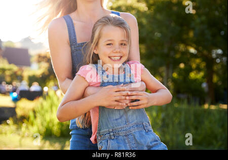 Close Up de Jeu de Mère et fille se balançant autour de jardin d'été Pub Banque D'Images