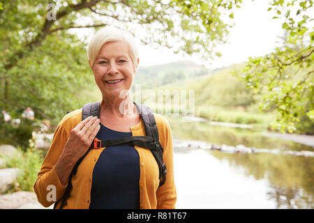 Portrait of Senior Woman randonnées le long du chemin de la rivière au Royaume-Uni Lake District Banque D'Images