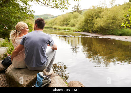 Couple sur la randonnée avec Vue sur Rivière de Lake District UK Banque D'Images