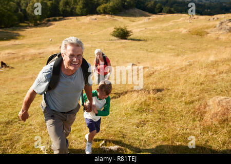 Les grands-parents avec leurs petits-enfants sur la Colline Escalade Randonnée pédestre dans la campagne dans la région de Lake District UK Ensemble Banque D'Images