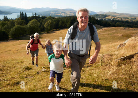 Les grands-parents avec leurs petits-enfants sur la Colline Escalade Randonnée pédestre dans la campagne dans la région de Lake District UK Ensemble Banque D'Images