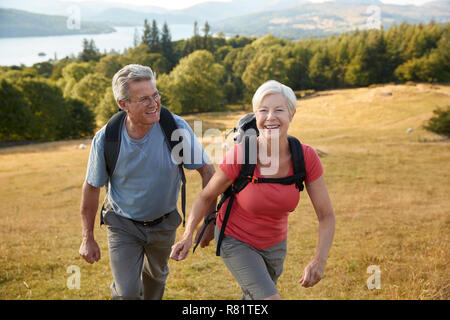 Couple sur la Colline Escalade Randonnée pédestre dans la campagne dans la région de Lake District UK Ensemble Banque D'Images